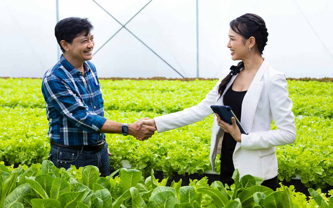 Handshaking between Asian farmer and his new local business entrepreneur